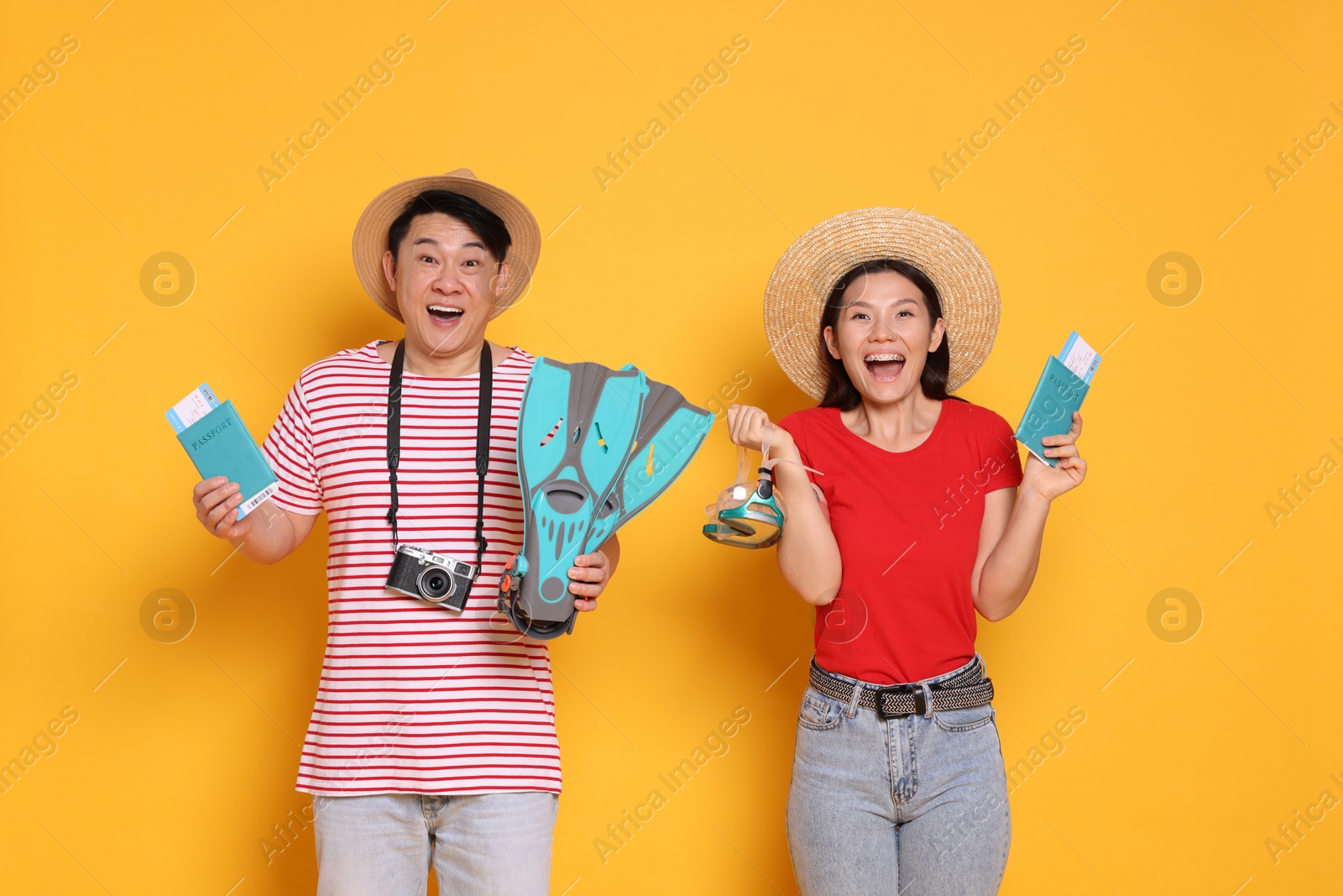 Photo of Excited travellers with passports and swim fins on yellow background