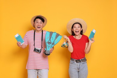 Photo of Excited travellers with passports and swim fins on yellow background