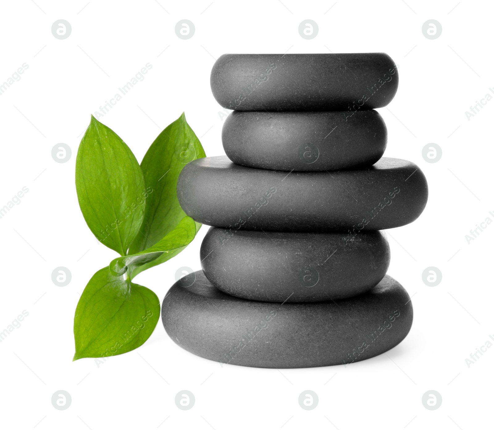 Photo of Stacked spa stones and green leaves isolated on white