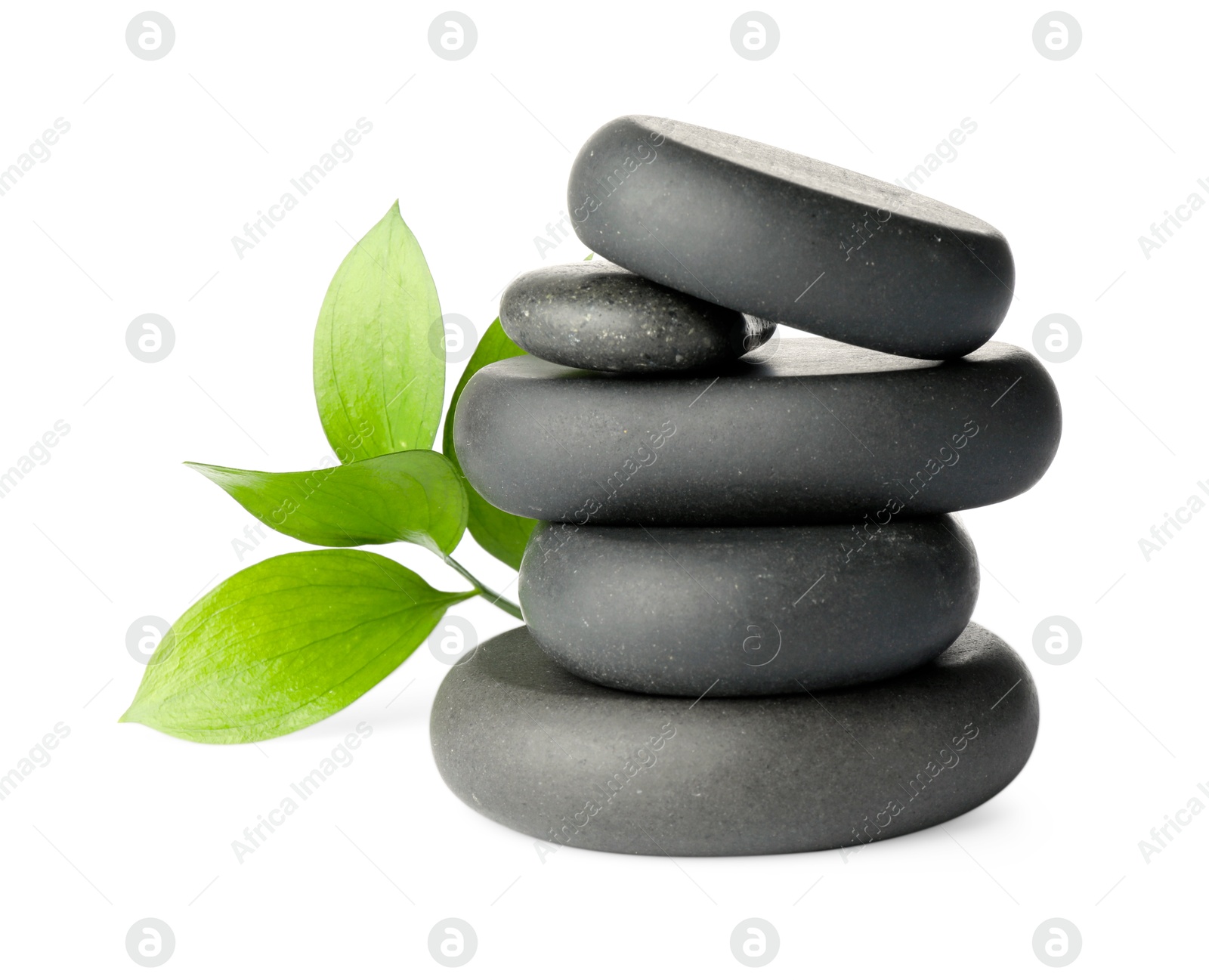 Photo of Stacked spa stones and green leaves isolated on white