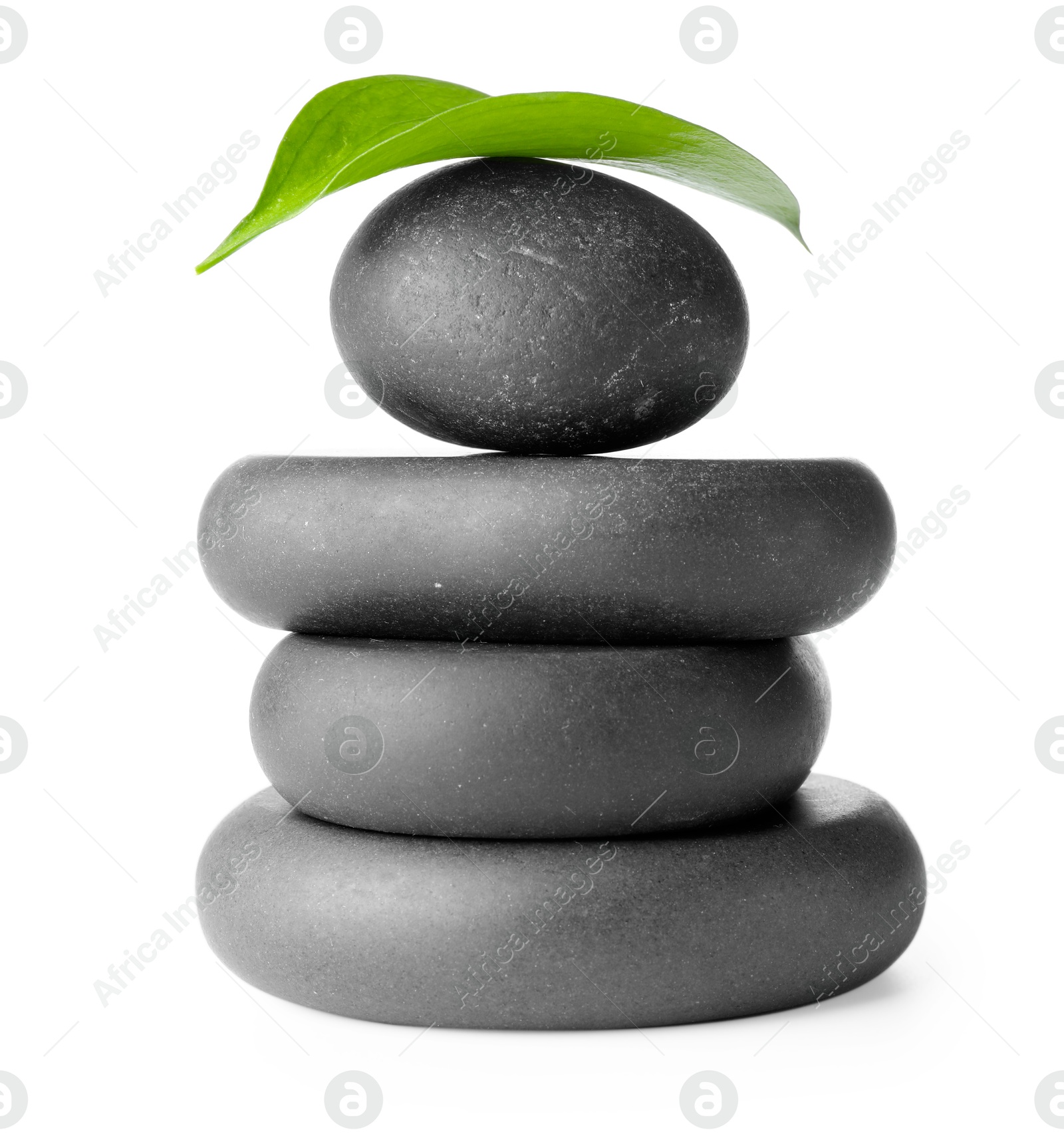 Photo of Stacked spa stones and green leaf isolated on white