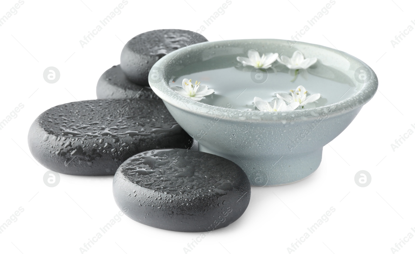 Photo of Wet spa stones and bowl of water with beautiful flowers isolated on white