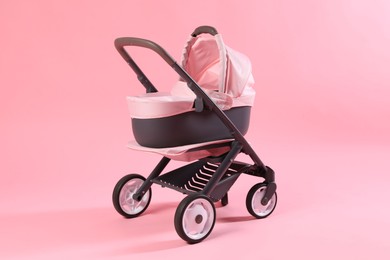 Photo of Stylish doll stroller on pink background. Kid's toy