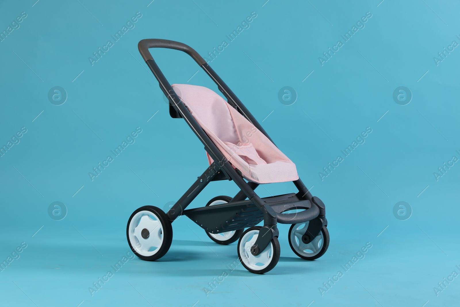 Photo of Doll stroller on light blue background. Kid's toy