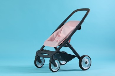 Photo of Doll stroller on light blue background. Kid's toy