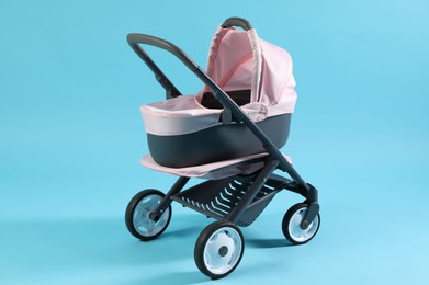 Photo of Doll stroller on light blue background. Kid's toy