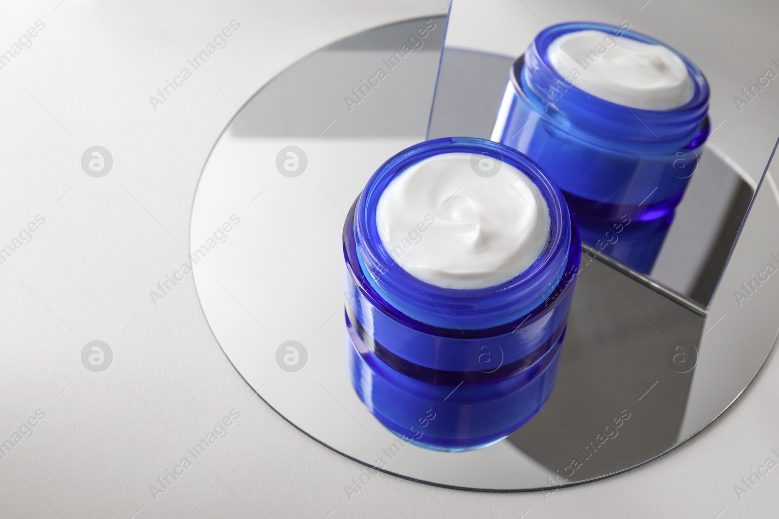 Photo of Stylish presentation of facial cream on light background, closeup. Space for text