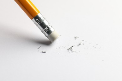 Photo of Using pencil with eraser on white sheet of paper, closeup