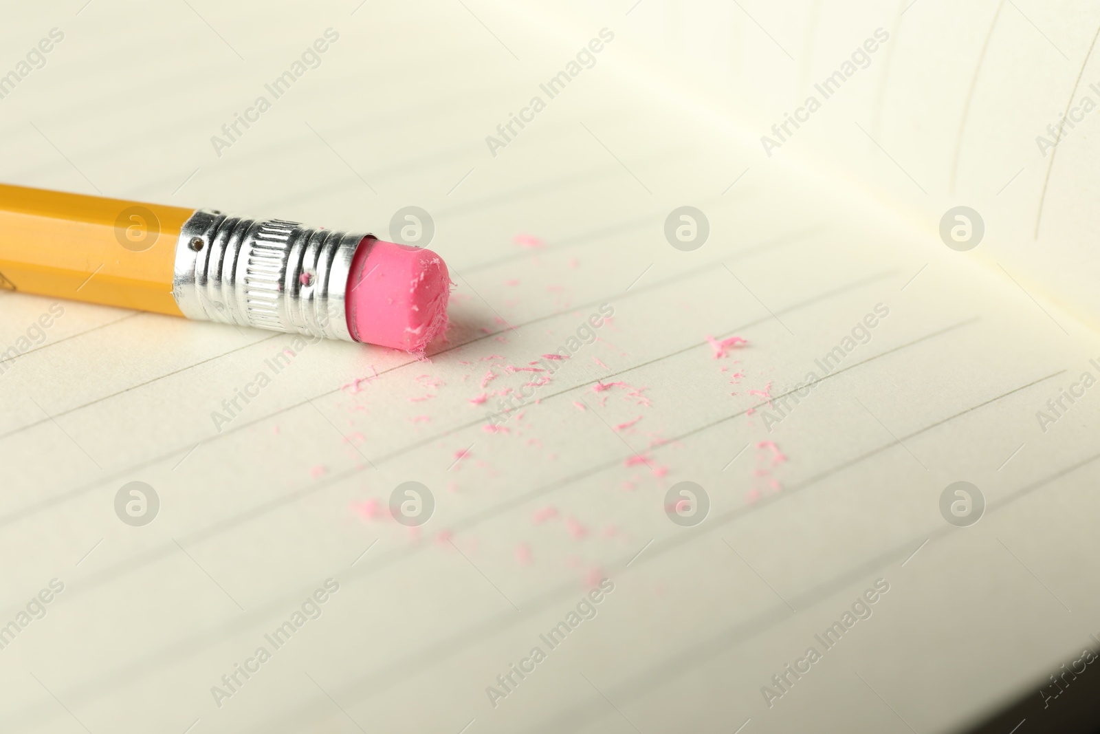Pencil with eraser and scraps on sheet of paper, closeup Photo of Pencil with eraser and scraps on sheet of paper, closeup