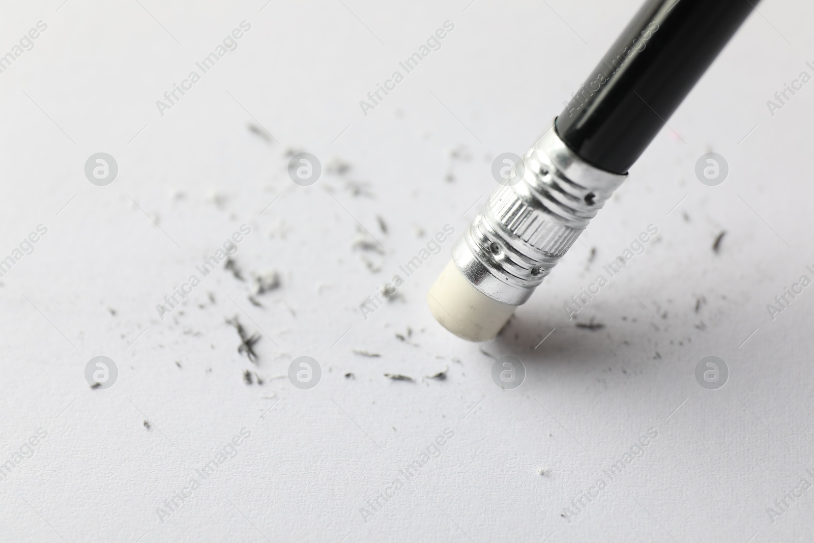 Photo of Using pencil with eraser on white sheet of paper, closeup