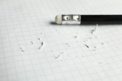 Photo of Pencil with eraser and scraps on white sheet of paper, selective focus