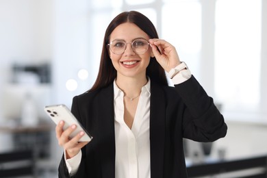 Photo of Portrait of banker with smartphone in office