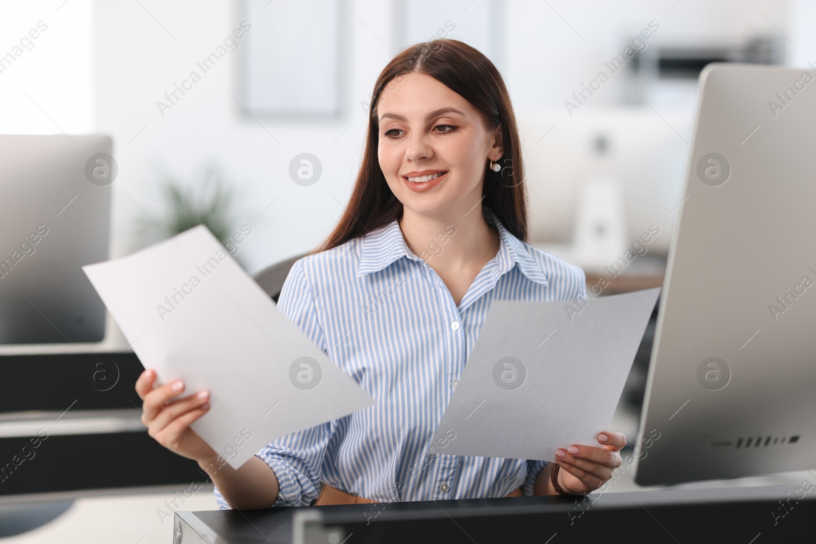 Photo of Banker with documents at desk in office