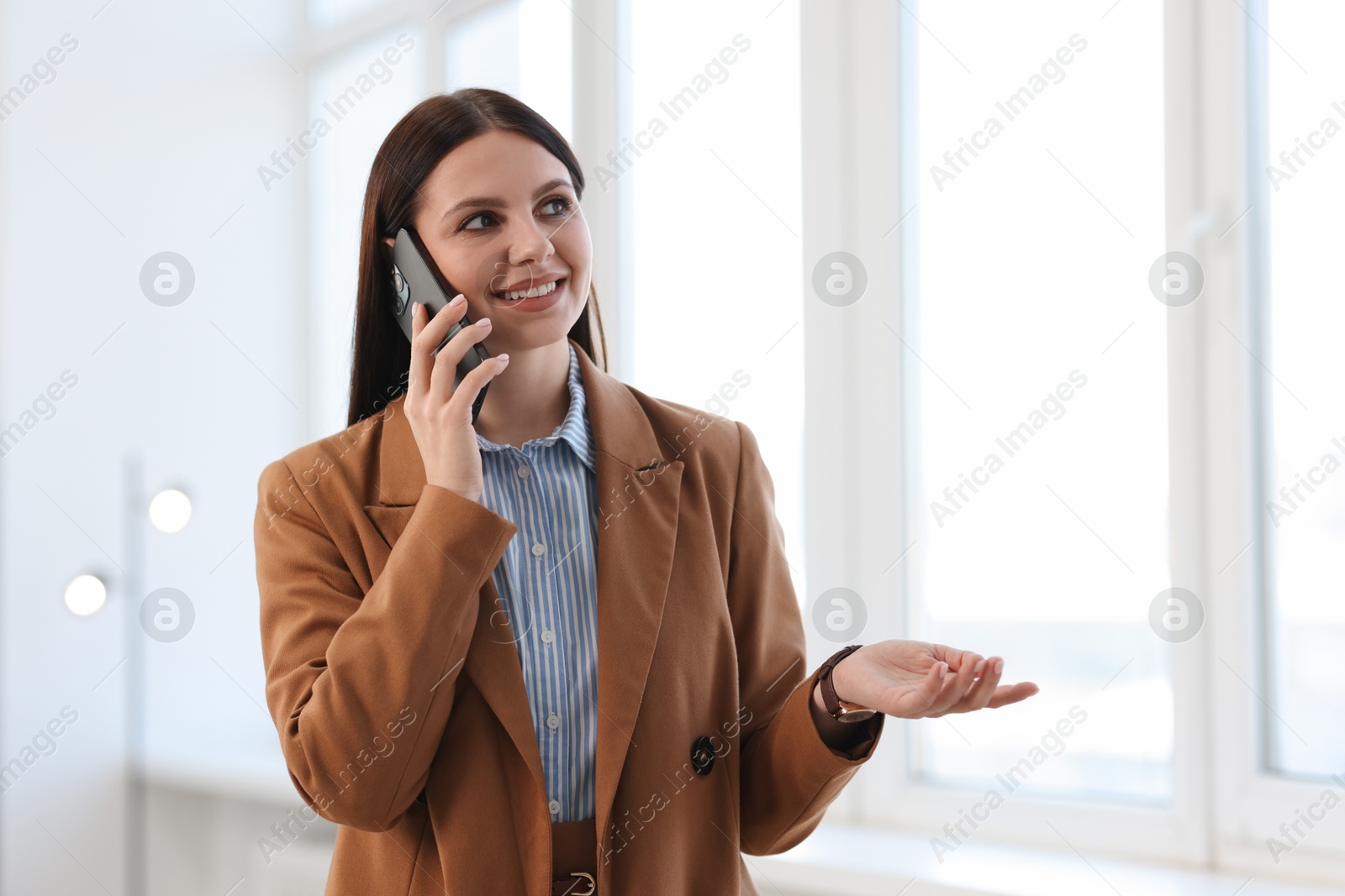 Photo of Portrait of banker talking on smartphone in office