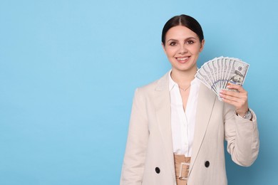 Photo of Banker with dollar banknotes on light blue background, space for text