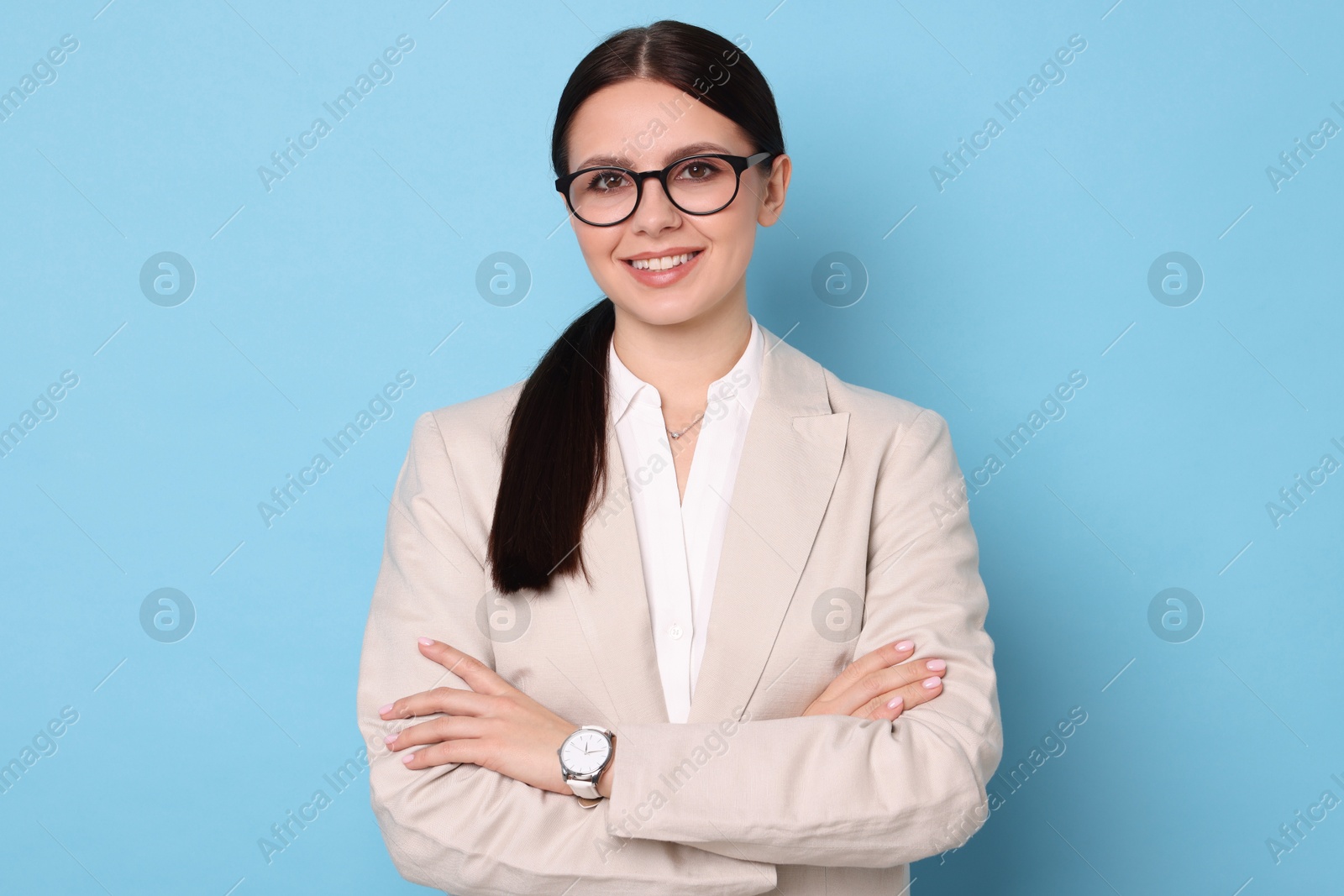 Photo of Portrait of banker with crossed arms on light blue background