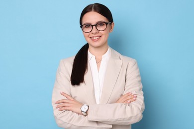 Photo of Portrait of banker with crossed arms on light blue background