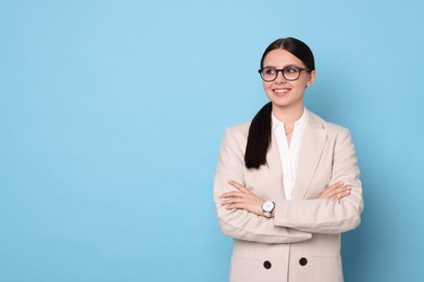 Photo of Portrait of banker with crossed arms on light blue background, space for text