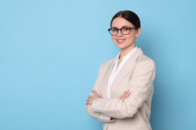 Photo of Portrait of banker with crossed arms on light blue background, space for text