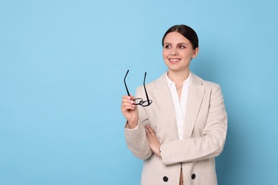 Photo of Portrait of banker with glasses on light blue background, space for text