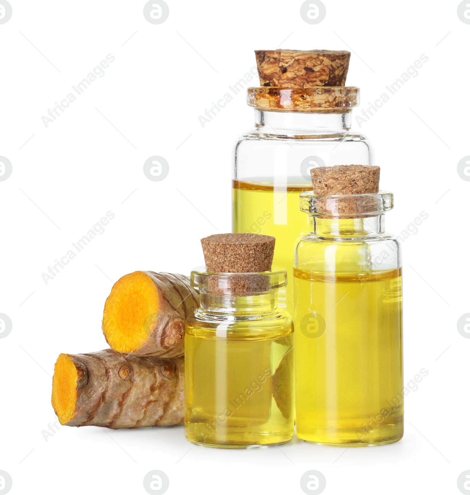 Photo of Bottles of turmeric essential oil and raw roots isolated on white