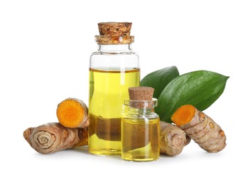 Photo of Bottles of turmeric essential oil, raw roots and leaves isolated on white