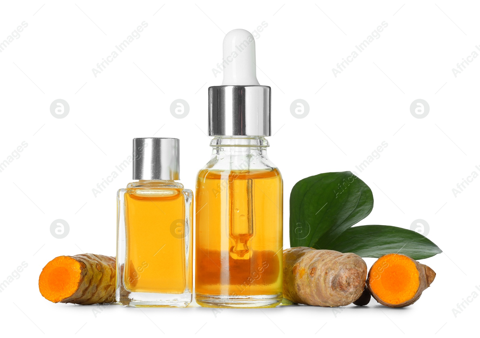 Photo of Bottles of turmeric essential oil, raw roots and leaves isolated on white