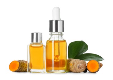 Photo of Bottles of turmeric essential oil, raw roots and leaves isolated on white