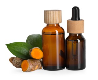 Photo of Bottles of turmeric essential oil, raw roots and leaves isolated on white