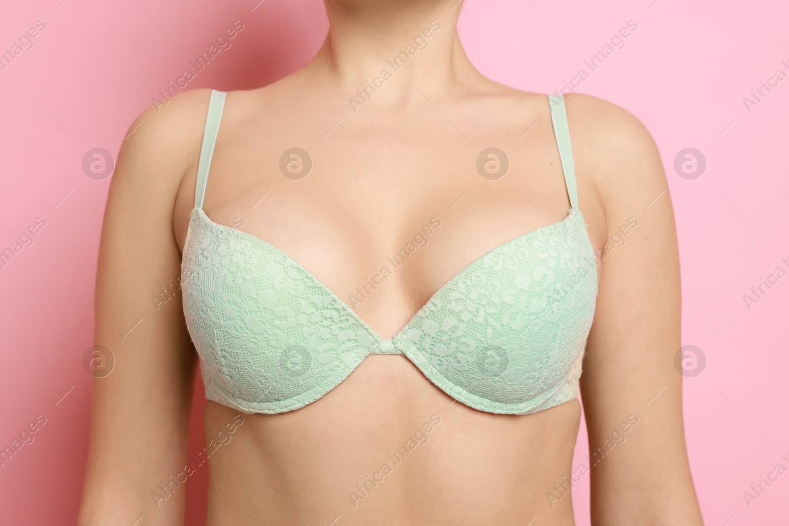 Photo of Woman wearing beautiful bra on pink background, closeup