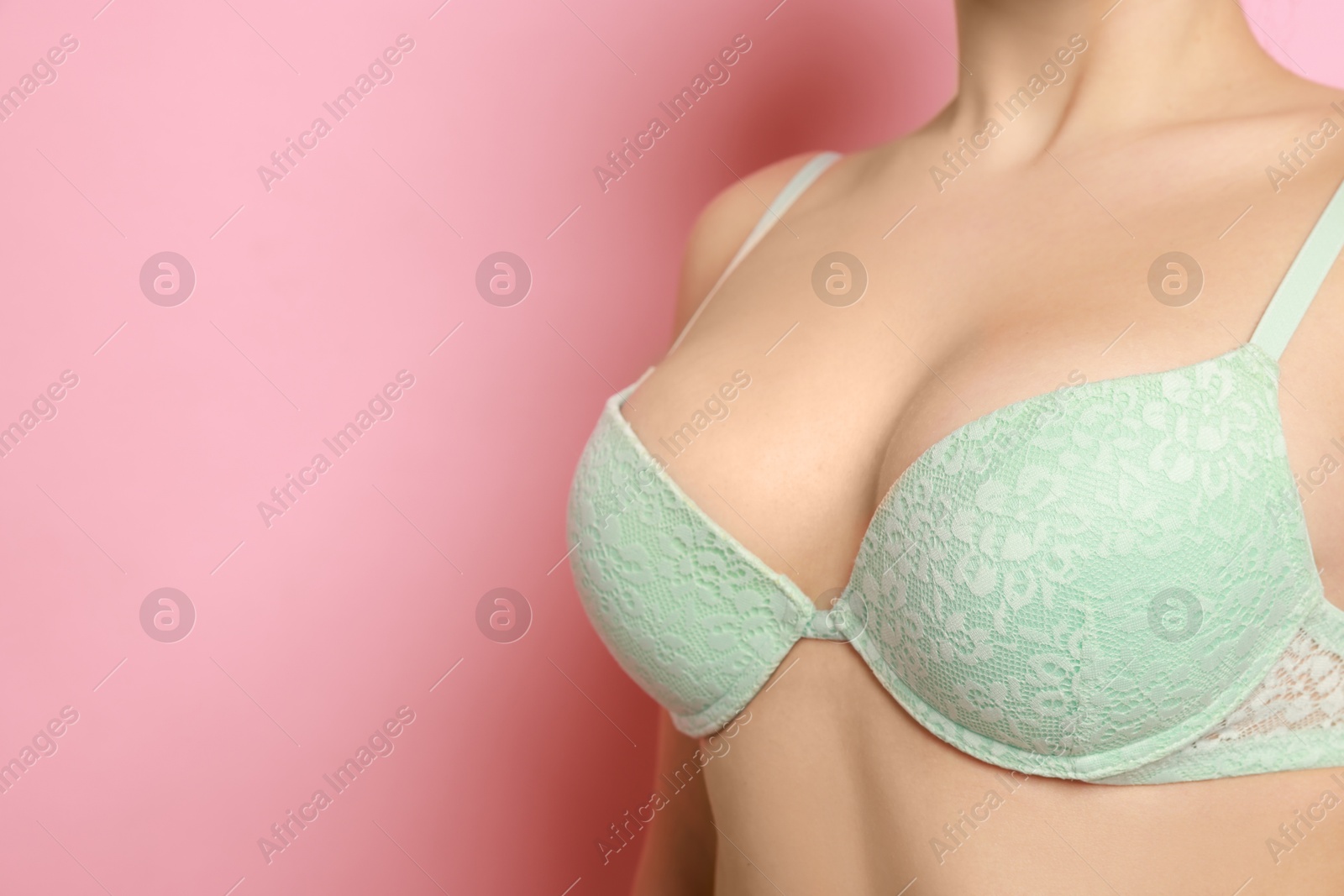 Photo of Woman wearing beautiful bra on pink background, closeup. Space for text