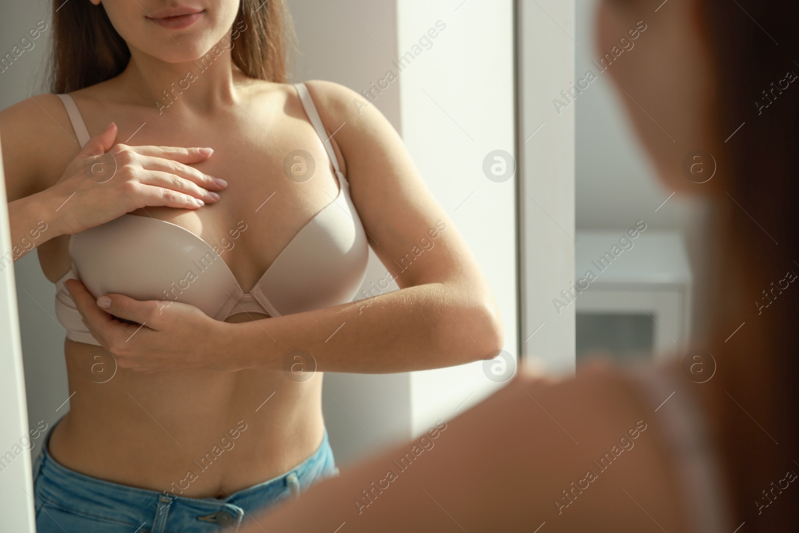 Photo of Woman wearing beautiful bra near mirror indoors, closeup