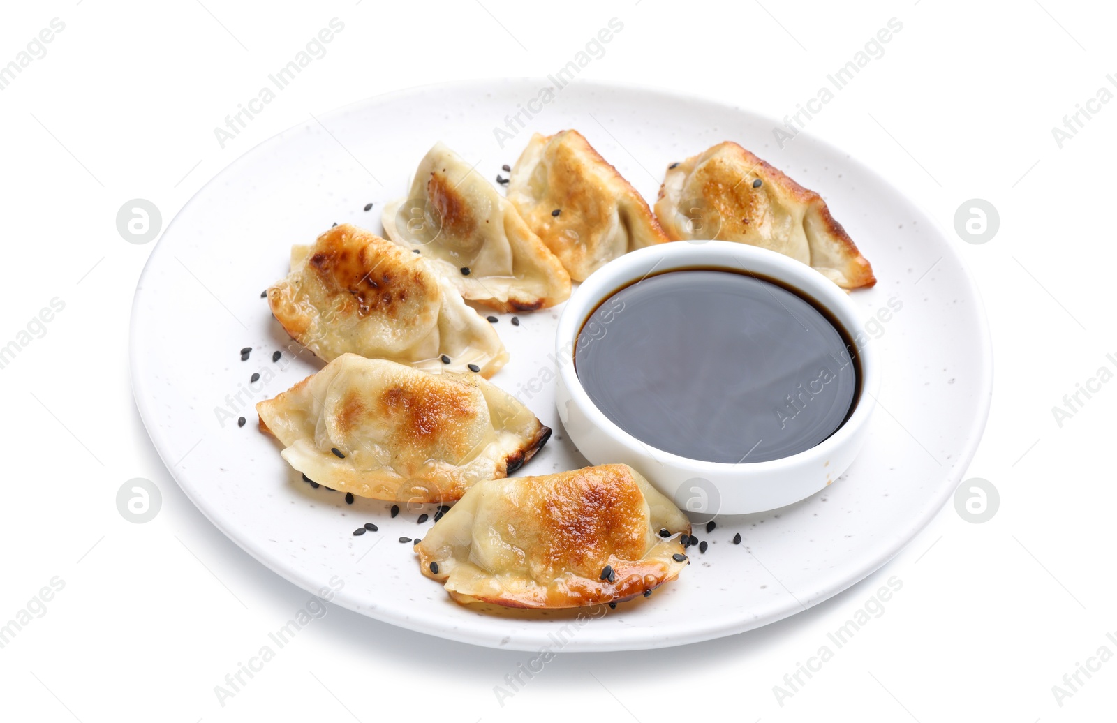 Photo of Delicious fried gyoza dumplings with sesame seeds and soy sauce isolated on white