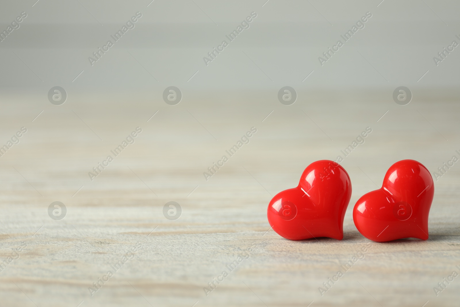 Photo of Valentine's Day. Decorative hearts on white wooden background, closeup. Space for text