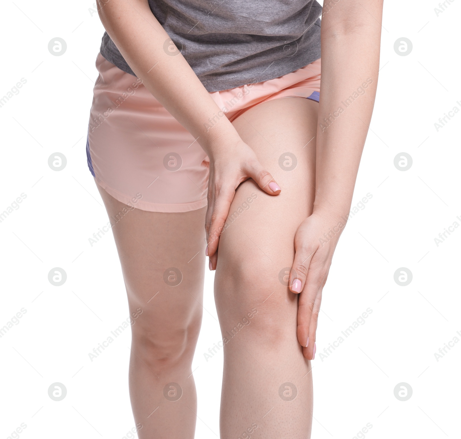 Photo of Young woman suffering from pain in knee on white background, closeup