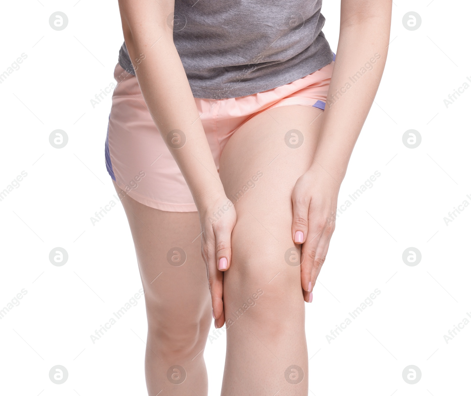 Photo of Young woman suffering from pain in knee on white background, closeup