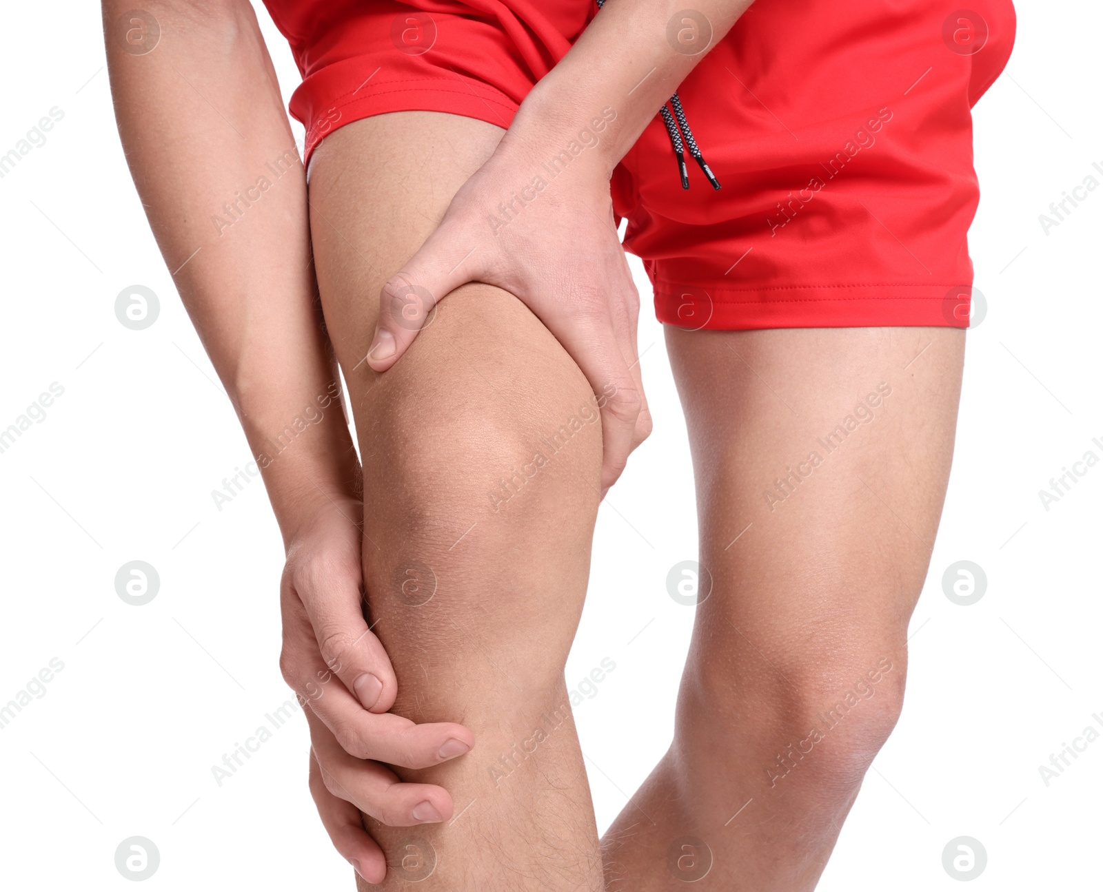 Photo of Young man suffering from pain in knee on white background, closeup