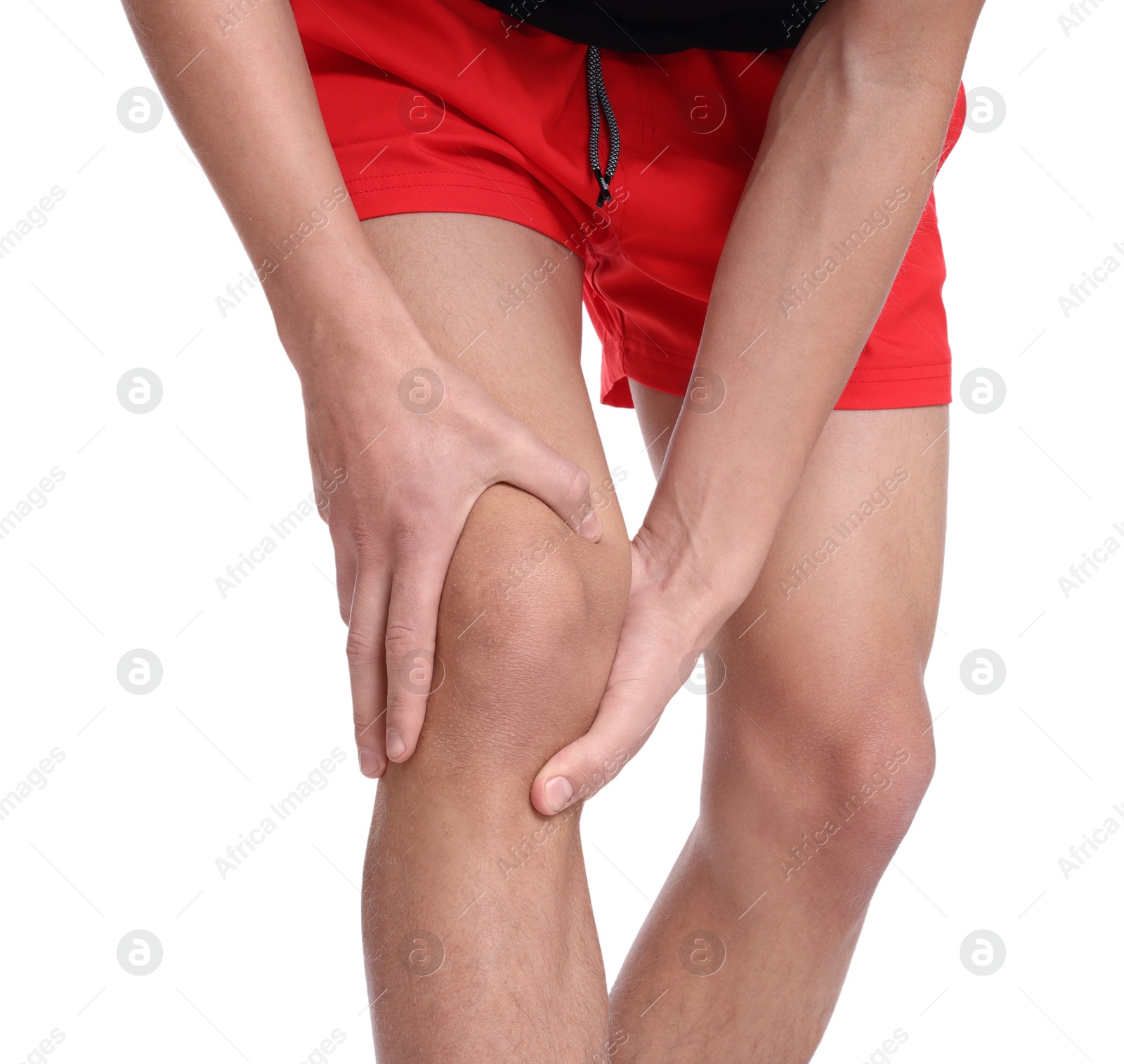 Photo of Young man suffering from pain in knee on white background, closeup