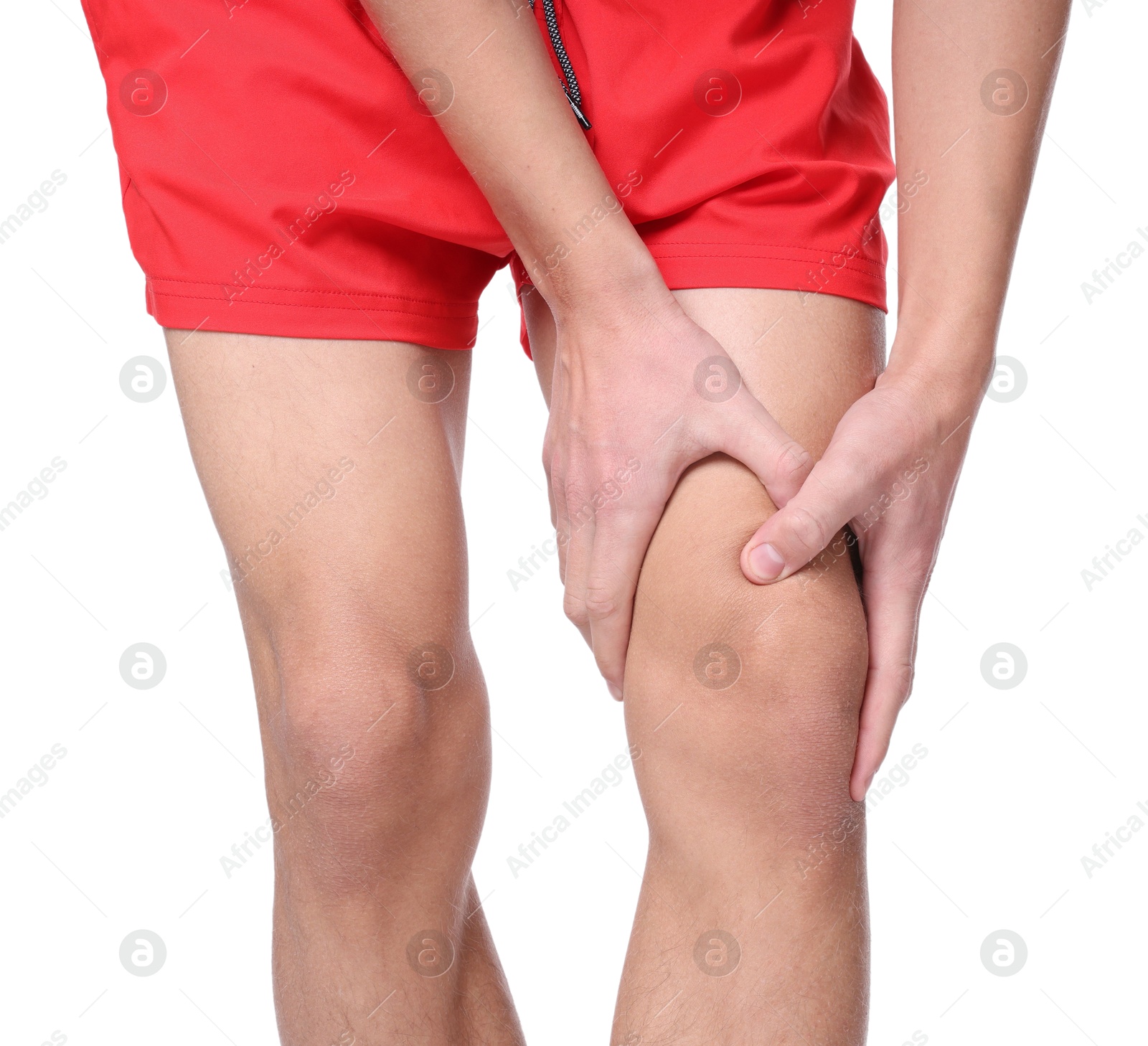 Photo of Young man suffering from pain in knee on white background, closeup