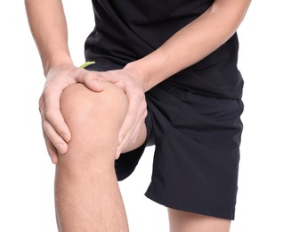 Photo of Young man suffering from pain in knee on white background, closeup