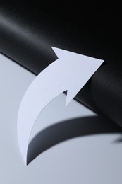 Photo of One white paper arrow on color background, closeup