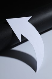 Photo of One white paper arrow on color background, closeup