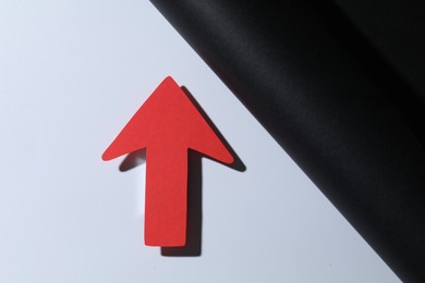 Photo of One red paper arrow on color background, top view