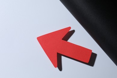 Photo of One red paper arrow on color background, top view