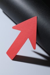 Photo of One red paper arrow on color background, closeup