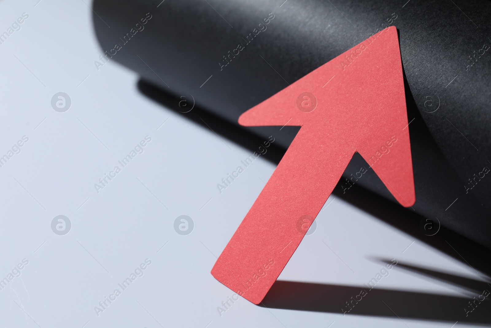 Photo of One red paper arrow on color background, closeup