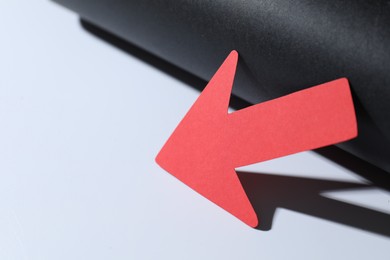 Photo of One red paper arrow on color background, closeup. Space for text