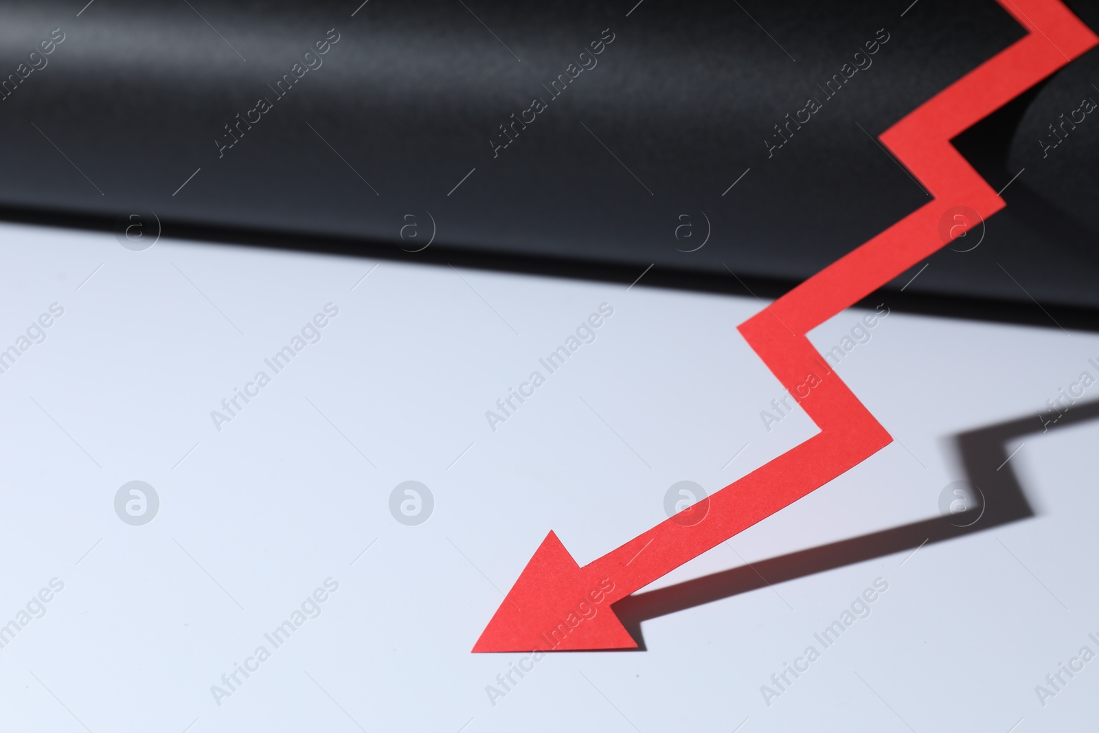 Photo of One red paper arrow on color background, closeup. Space for text