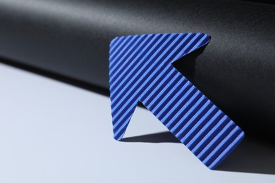 Photo of One blue paper arrow on color background, closeup