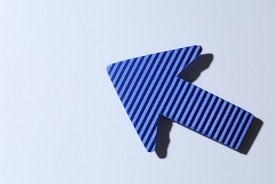 Photo of One blue paper arrow on white background, top view. Space for text